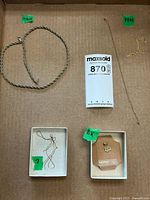 Overview of gold jewelry lot including two necklaces, pendant, and chain fragments with identification labels