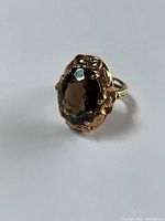 Front elevation showing faceted oval smokey quartz and floral claw setting