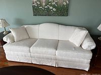 Full front view of three-seat sofa with two pillows on each end