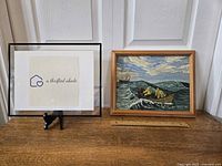 Overview of framed painting beside display stand