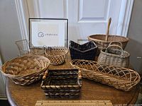 Eight assorted small wicker baskets on table showing variety of shapes, colors and weaving styles