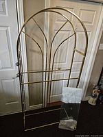 Full view of the brass etagere frame with glass shelves wrapped and separate on the floor.