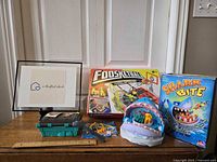 View of four children's tabletop games including Foosketball, Shark Bite, and two food-themed puzzle/fishing games