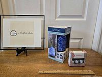 Photo showing Airome essential oil diffuser box with blue and white swirl design and Serenity essential oils set boxed together on a wooden surface