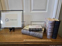 Four Paris themed decorative box journals shown standing and stacked on a wooden table with a ruler for scale, in front of white paneled doors.