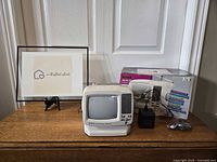 GPX portable TV with original box and accessories displayed on table, showing packaging and device condition.