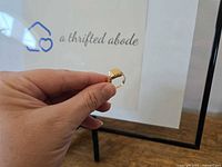 Full view of ring held by hand showing overall shape and finish