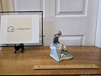 Figurine and seller branding visible with scale reference on wooden surface, showing overall size and condition.