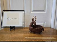 Reindeer wicker basket with sign next to it showing lot is from a thrifted abode, basket is intact with eyes, tail and antlers.