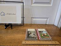 Two vintage books placed side by side on a wooden surface, with a ruler for scale, showing the full front covers and overall condition.