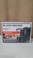 Box of Black+Decker 1.5-Cup Food Chopper HC150B showing brand, model, capacity, features, and 2 year warranty.
