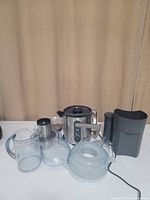 Full view of Breville juicer with all visible attachments including clear juice jug, pulp container, lid, and filter.