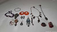 Full lot spread out showing assortment of costume jewelry including bracelets, earrings, and necklaces of various styles and colors