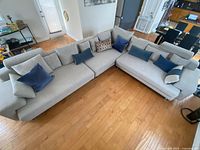 Full front view of the three-piece sectional arranged in L-shape with accent pillows