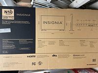 Box with Insignia branding and detailed specifications, including model number, dimensions, and features like Full HD 1080p resolution, HDMI, DTS, and Dolby Audio.