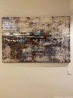 Front view of rectangular multicolor abstract painting on canvas, showing layered textured brush strokes and mixed neutral and accent colors.