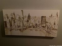 Photo of a rectangular canvas painting portraying the New York City skyline in a sepia-tone artistic style with skyscrapers and bridge.