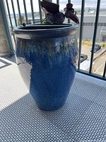 Large ceramic planter with gradient blue glaze and metal bird ornament on rim