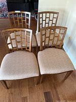 Four chairs grouped together on hardwood floor showing front view
