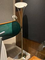 Full view of the brass floor lamp with torchiere and adjustable reading light, showing the design and shape.