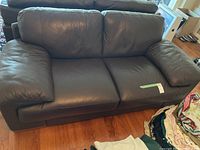 Front view of dark brown leather sofa showing seating area and cushions