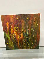 Front view of the square modern abstract oil painting showing vibrant warm colors and splatter technique.