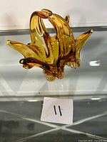 Front angle view of the amber chalet glass vase showing its unique curved and pointed design with translucent amber color.