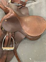 Full view of saddle seat, flap, and stirrup irons laid flat
