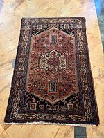 Full view of rug on tiled floor showing overall design and condition