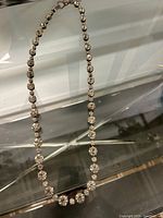 Full view of the necklace showing the graduated round faceted clear crystals strung symmetrically.