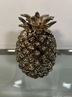 Front view of the metal pineapple decor showing detailed texture and metallic finish.