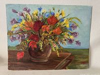 Front view of the colorful floral oil painting on board by Mary MacNaughton showing the entire artwork including the wooden table and background.