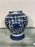 Front angle view of the blue and white Chinese porcelain jar showcasing its traditional floral and symbolic blue patterns on white porcelain, the jar stands on a flared base.