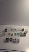 Overview of bead lot in multiple small clear plastic containers and jars