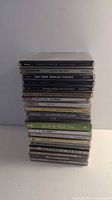 Stack of 19 CD cases showing artist names and album titles on spines
