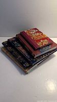 Stack of six fabric-covered journals showing different covers and patterns