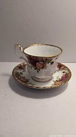 Photo of Royal Albert Old Country Roses teacup with floral pattern and gold trim, placed on saucer