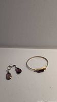 Pair of earrings and bangle against white background showing the full lot contents