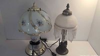 Two vintage nightstand lamps placed side by side, showing different styles and detailed features.