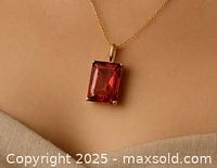 Pendant worn to show scale and how it looks when worn, with pink lab diamond emerald cut and gold chain visible.