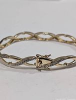 Close-up of sterling silver bracelet clasp and part of chain links, showing detail of embedded cubic zirconia stones.