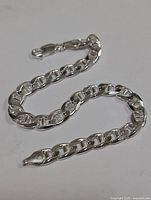Silver chain link bracelet arranged to show overall length and link style