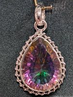 Close-up image of the pendant showing a teardrop-shaped mystic topaz stone in a decorative sterling silver setting.