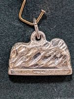 Silver pendant with textured mountain back surface stamped "STERLING"