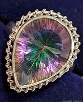 Close-up front view of the pear-shaped mystic topaz stone with twisted rope-like silver bezel setting on a dark background.