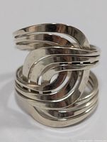 Front close-up showing the interwoven and layered bands of the silver ring.