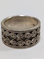 Front view showing the engraved spiral pattern and twisted rope edges on the silver band ring.