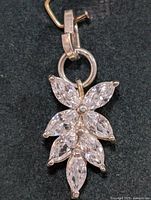 Close-up front view of silver pendant showing leaf-shaped cluster of marquise cut cubic zirconia stones.