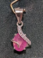 Close-up photo of the silver pendant showing the ruby and accent stones clearly.