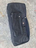 Black soft Gator case for musical instruments laid flat showing front side with zipper pocket and handle.